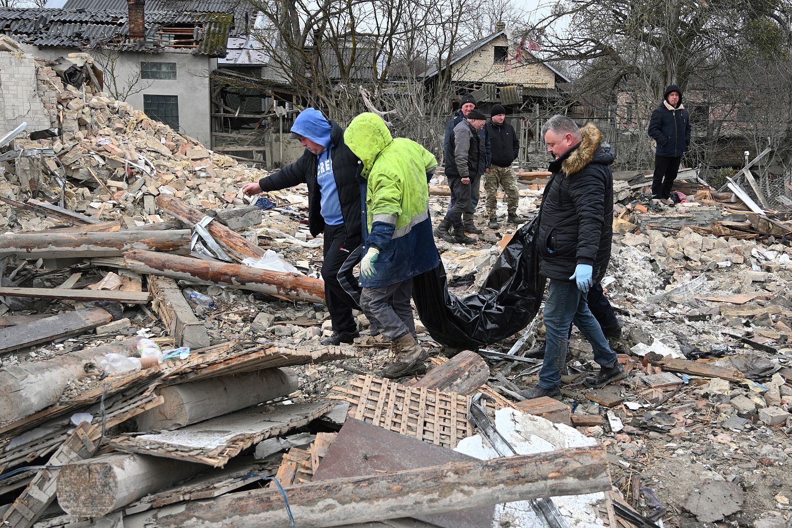 Police experts and local residents carry an unidentified body following a Russian strike in the village of Velyka Vilshanytsia, some 50km from Lviv, Ukraine. March 9, 2023