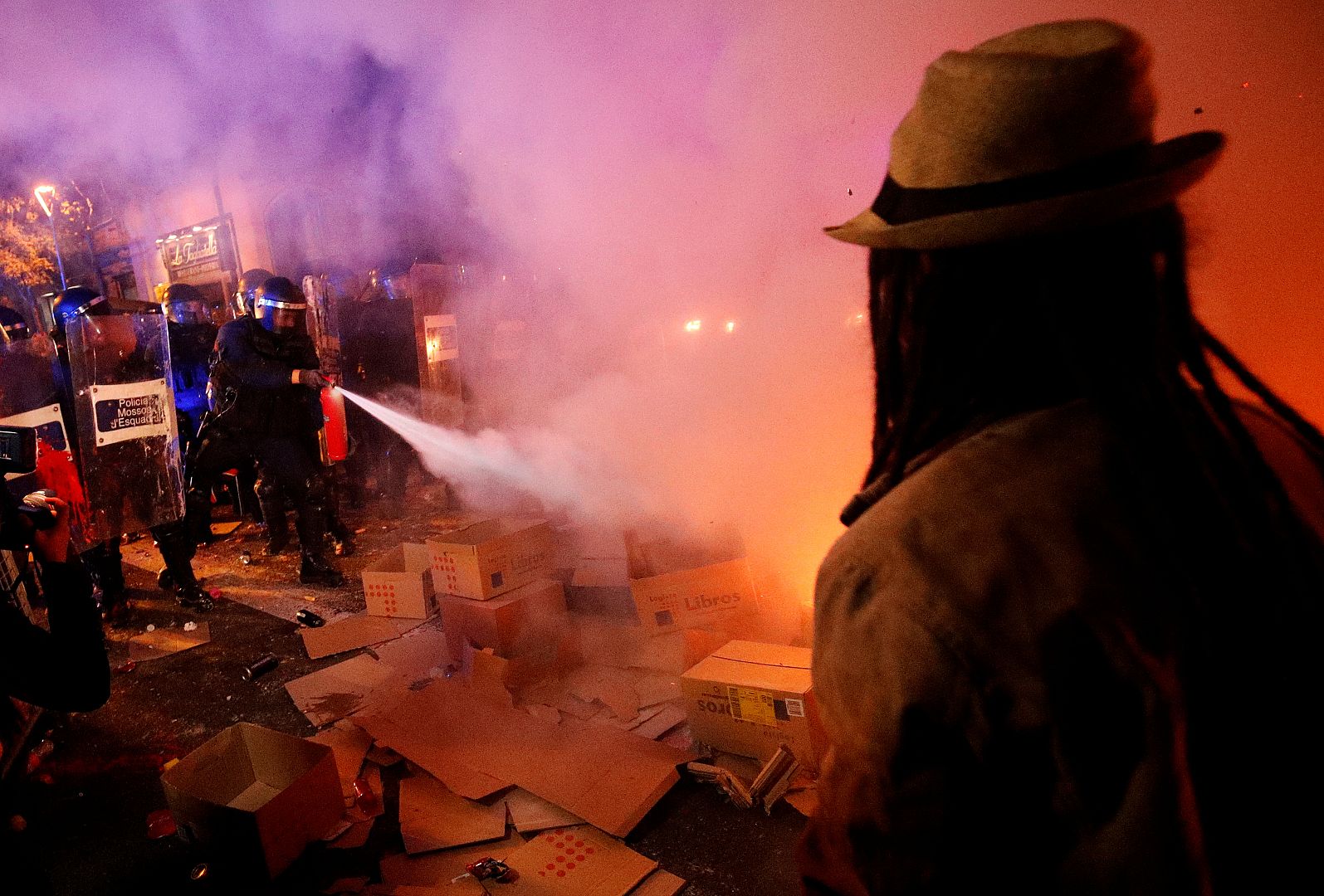 Policía antidisturbios apagando el fuego durante una protesta en Barcelona, España, el 15 de octubre de 2019.