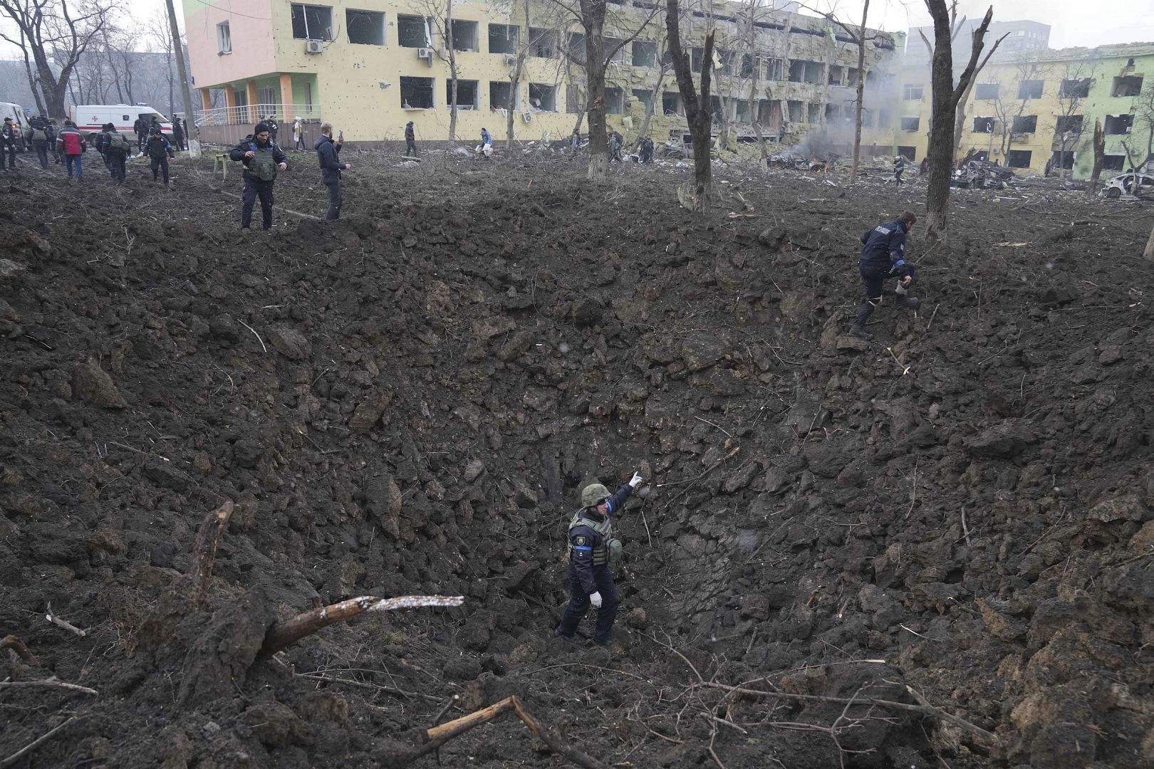 Ukrainische Soldaten und Notfallhelfer arbeiten an der Seite des durch Beschuss beschädigten Entbindungskrankenhauses in Mariupol, Ukraine. 9. März 2022.
