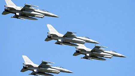 Des avions de chasse américains F-16 survolent Varsovie lors d'une grande parade militaire  pour célébrer le jour de l'armée polonaise, 15 août 2023