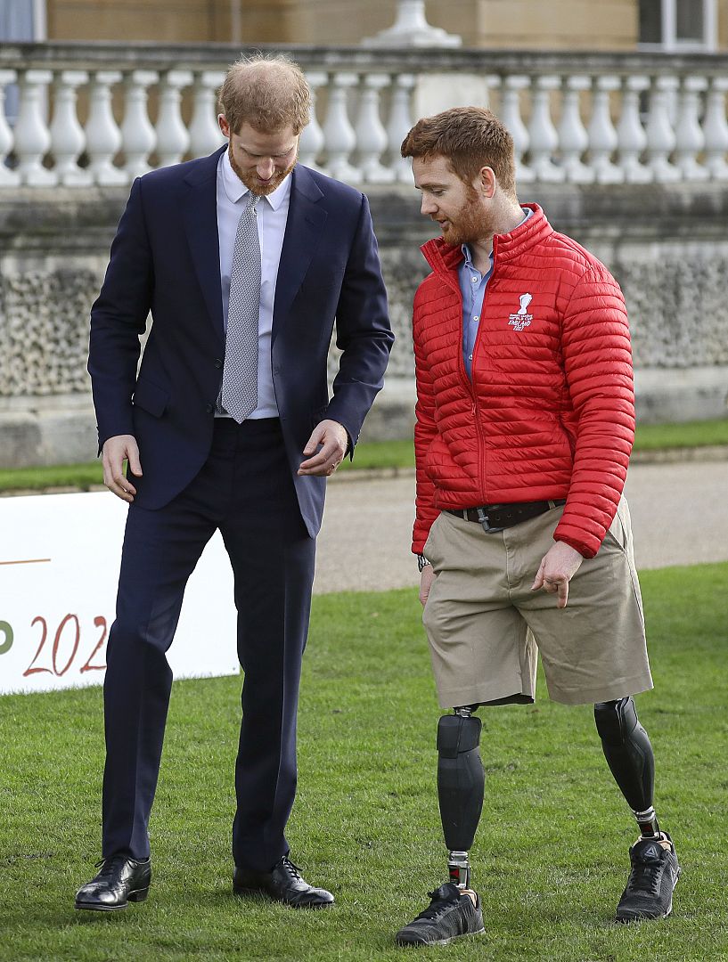 Britain's Prince Harry walks with Rugby League World Cup 2021 ambassador James Simpson in the gardens at Buckingham Palace in London. 16 January 2020.