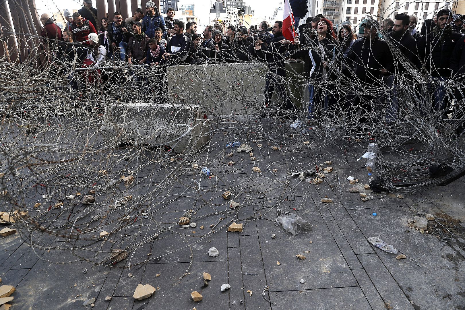 Anti-government protesters stand behind barbed wires that set by security force in downtown Beirut, Lebanon. 27January 2020.