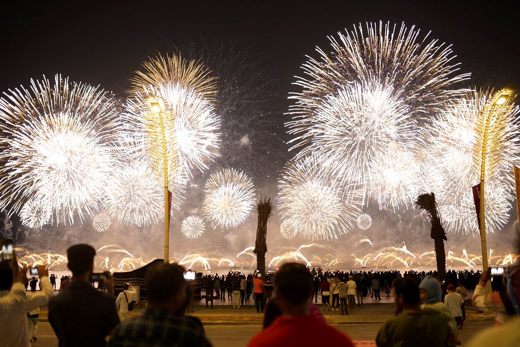 Fans watch fireworks after the World Cup inauguration match between Qatar and Ecuador at the Corniche sea promenade in Doha, Qatar, Sunday, Nov. 20, 2022
