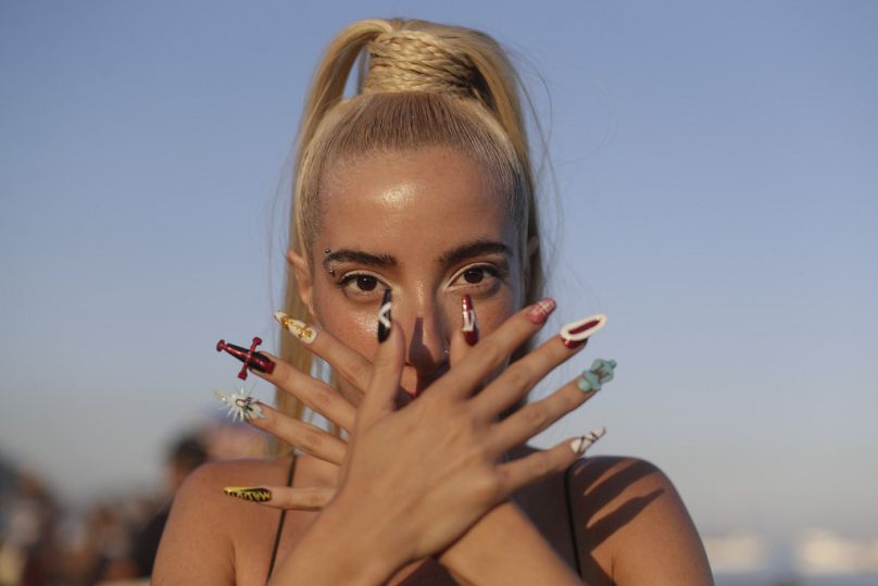 Una brasileña con uñas postizas espera el gran espectáculo en la playa de Copacabana