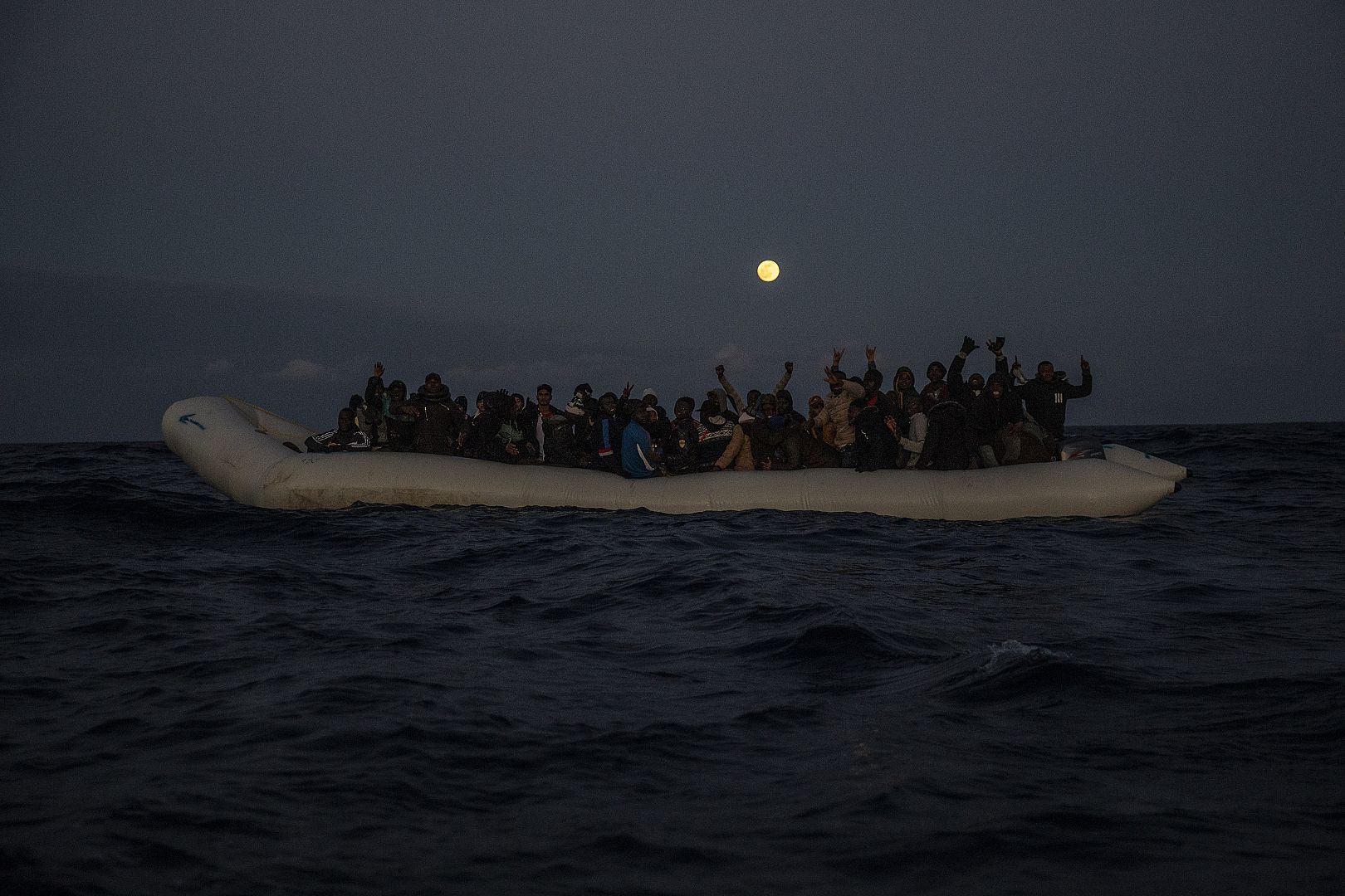 The aid workers of the Spanish NGO Open Arms approach the migrants and refugees from different African nationalities on an overcrowded rubber boat off the Libyan coast.