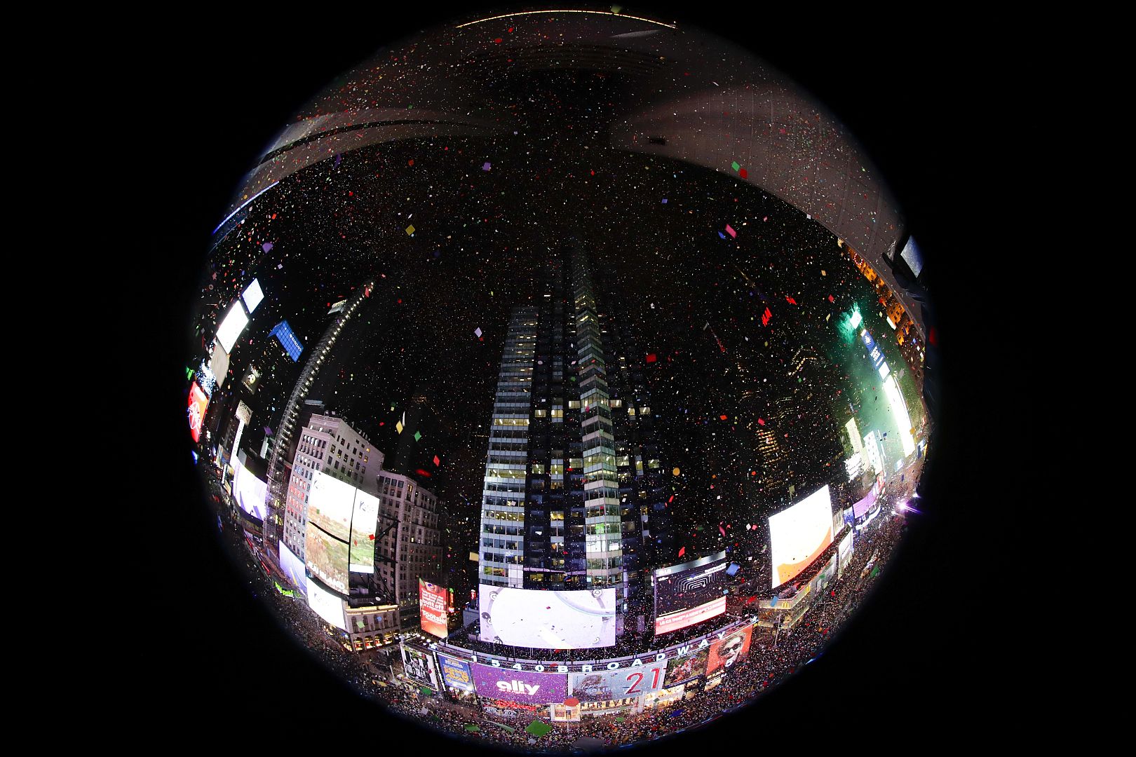 Confetti drops over the crowd as the clock strikes midnight during the New Year's celebration in New York's Times Square, 1 January, 2020.