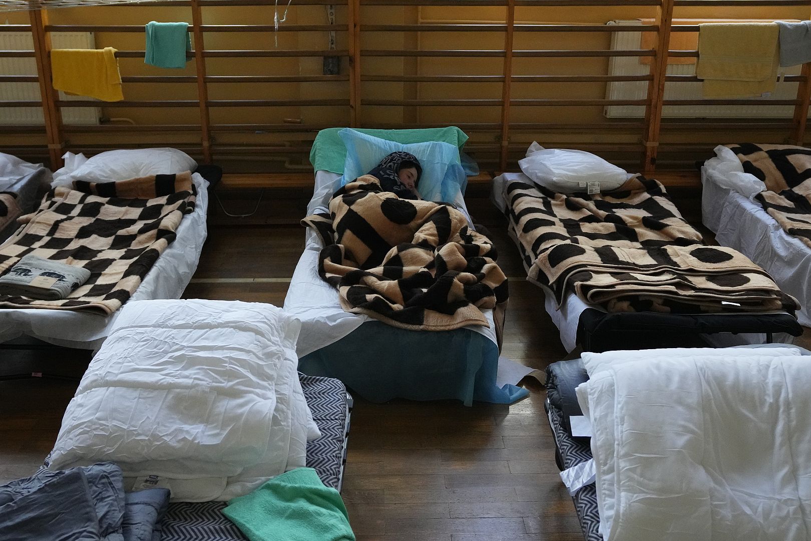 A refugee who fled the war from neighboring Ukraine rests in a school building in Przemysl, Poland. February 26, 2022. Petr David Josek/ AP Photo