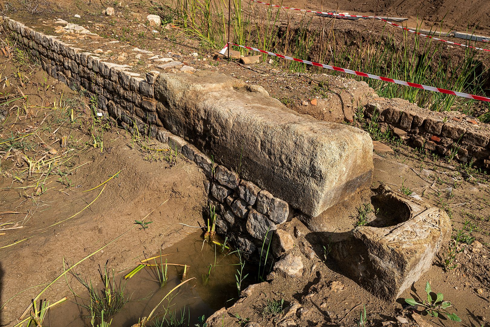 Murs d’enclos avec seuil et bloc d’angle constitués de stèles en remploi