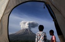 Indonesian children watch Mount Sinabung erupting in Karo, North Sumatra, Indonesia. March 11, 2021