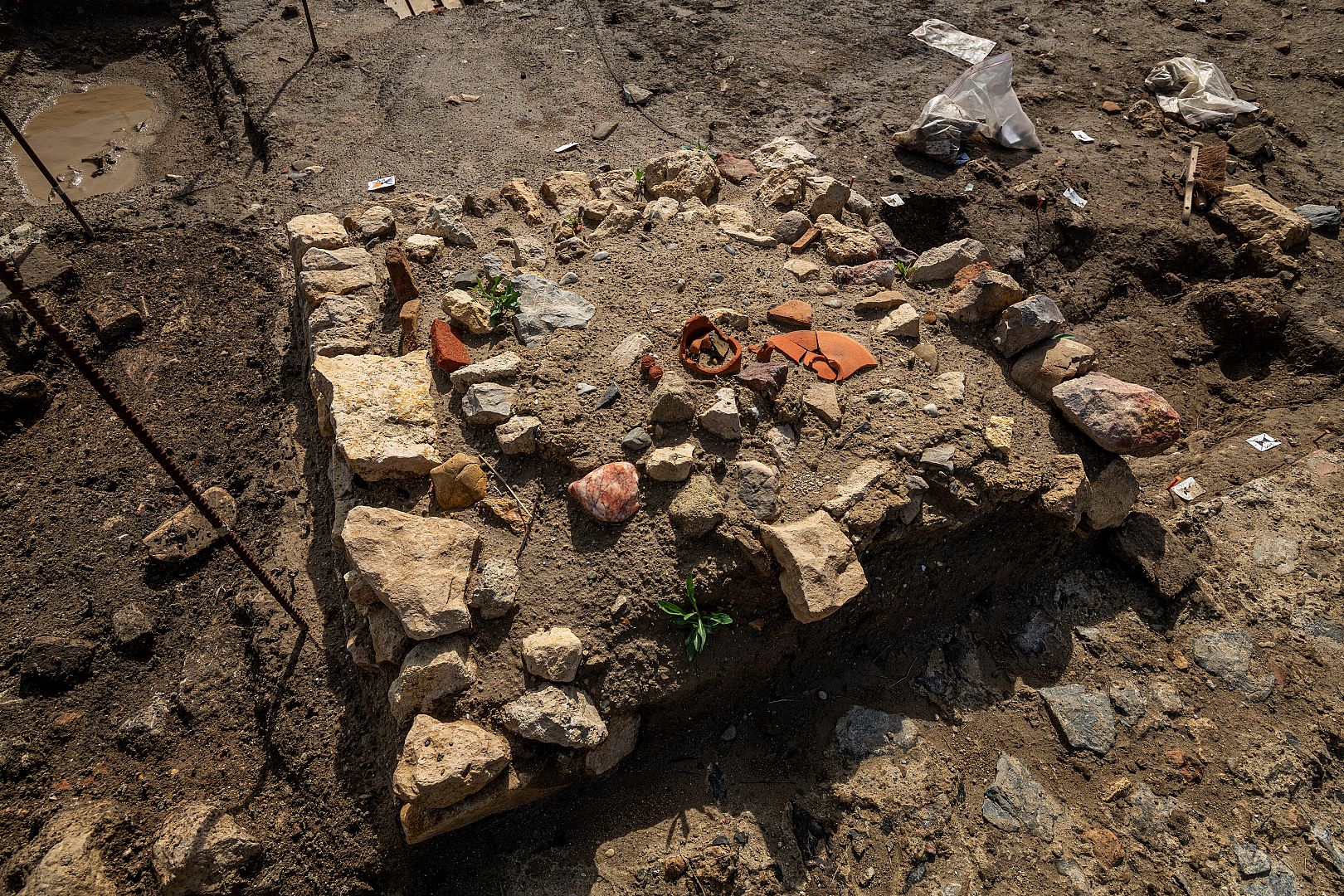 Petit monument funéraire installé sur une tombe avec au centre le sommet de l’amphore utilisée comme conduit à libation et intégrée à la maçonnerie.