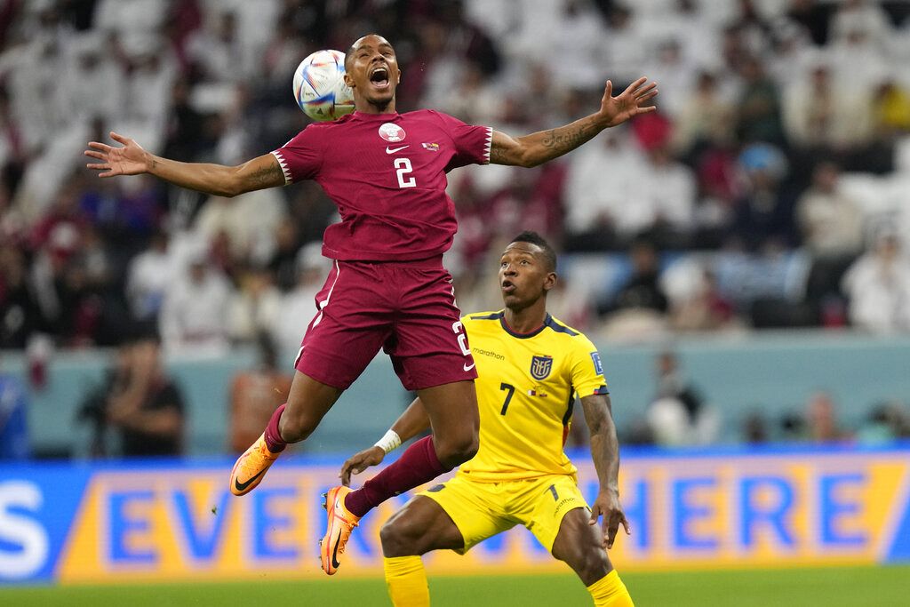 Qatar's Pedro Miguel, left, challenges for the ball with Ecuador's Pervis Estupinan during the World Cup group A soccer match