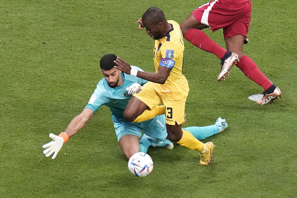 Ecuador's Enner Valencia, centre, is fouled by Qatar's goalkeeper Saad Al Sheeb, left, during match between Qatar and Ecuador