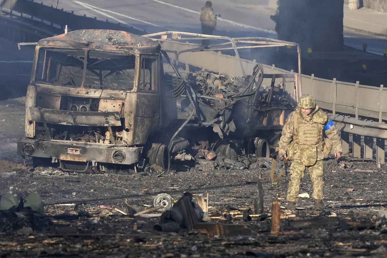 A Ukrainian soldier walks past debris of a burning military truck, on a street in Kyiv, Ukraine. February 26, 2022