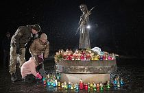 Menschen legen Blumen nieder am Denkmal für die Opfer des Holodomor, der großen Hungersnot, nieder, bei der in den 1930er Jahren Millionen Menschen starben