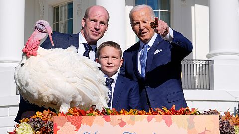 President Joe Biden, right, stands with John Zimmerman, left, chair of the National Turkey Federation, his son Grant Zimmerman, center, and the national Thanksgiving turkey