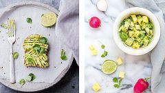 Two avocado halves filled with hummus and with spices and flowers.