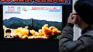 Egy férfi nézi a rakétakilövésről szóló hírt a tévében Tokióban