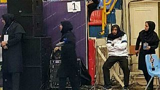 مدرب منتخب سيدات تايلندا، في المنتصف، يرتدي الحجاب لحضور مباراة فريقه