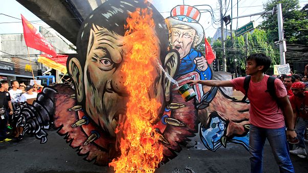 An activist pours gasoline as an effigy of President Rodrigo Duterte An activist pours gasoline as an effigy of President Rodrigo Duterte