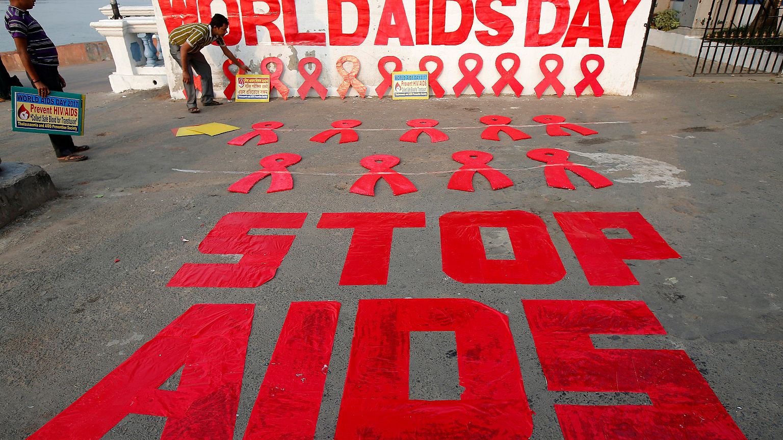 A man places a placard as he prepares a message during an HIV/AIDS awarenes