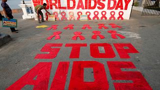 A man places a placard as he prepares a message during an HIV/AIDS awarenes