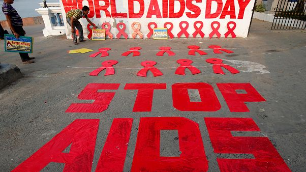 A man places a placard as he prepares a message during an HIV/AIDS awarenes A man places a placard as he prepares a message during an HIV/AIDS awarenes