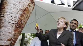 German Chancellor Angela Merkel cuts a piece from a kebab meat loaf 
