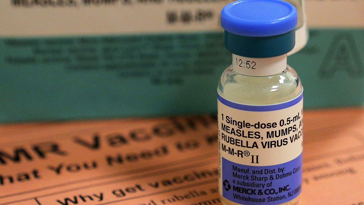 A vial of measles, mumps and rubella vaccine and an information sheet is se