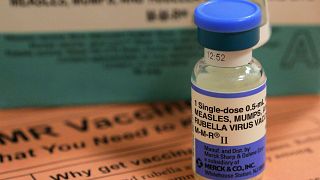 A vial of measles, mumps and rubella vaccine and an information sheet is se