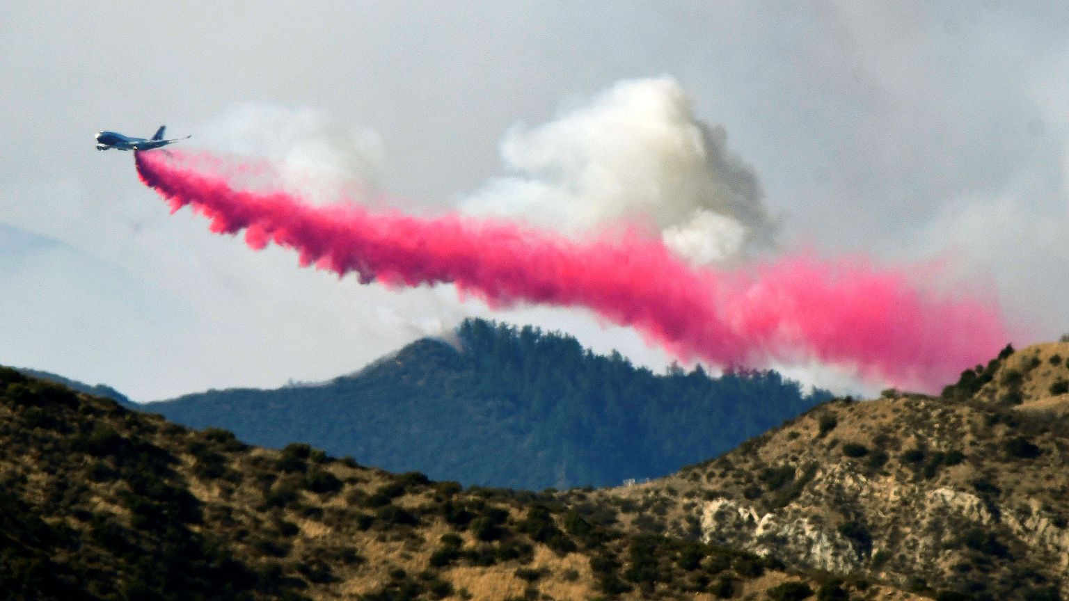 An aircraft drops fire retardant on a wildfire in Filmore, California 