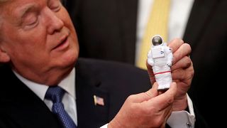 President Trump holding an astronaut toy at the signing ceremony, Dec. 11