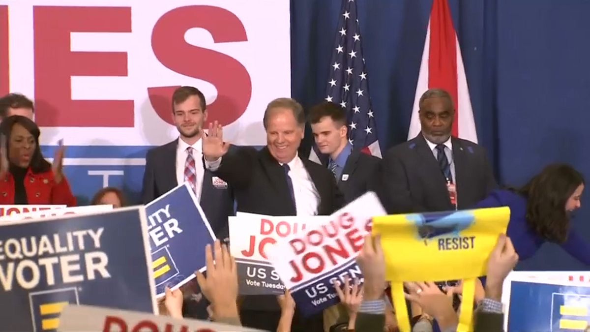 Doug Jones saluda a sus seguidores tras la victoria