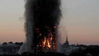 Flames and smoke billow as firefighters deal with a fire in the Grenfell To