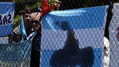 People stand next to a bouquet of flowers in support of missing submarine