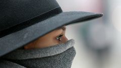 Woman walks with a covered face to protect herself from air pollution