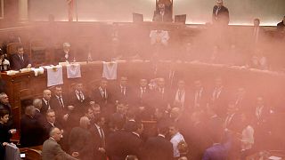 Albania's opposition lawmakers throw smoke bombs inside the Parliament