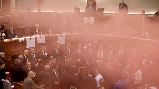 Albania's opposition lawmakers throw smoke bombs inside the Parliament 