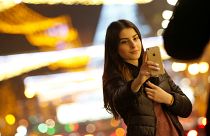 A woman takes a selfie on a street with Christmas decoration in Tbilisi, Ge