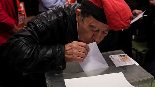  Mann mit traditioneller katalanischen Mütze küsst seinen Stimmzettel