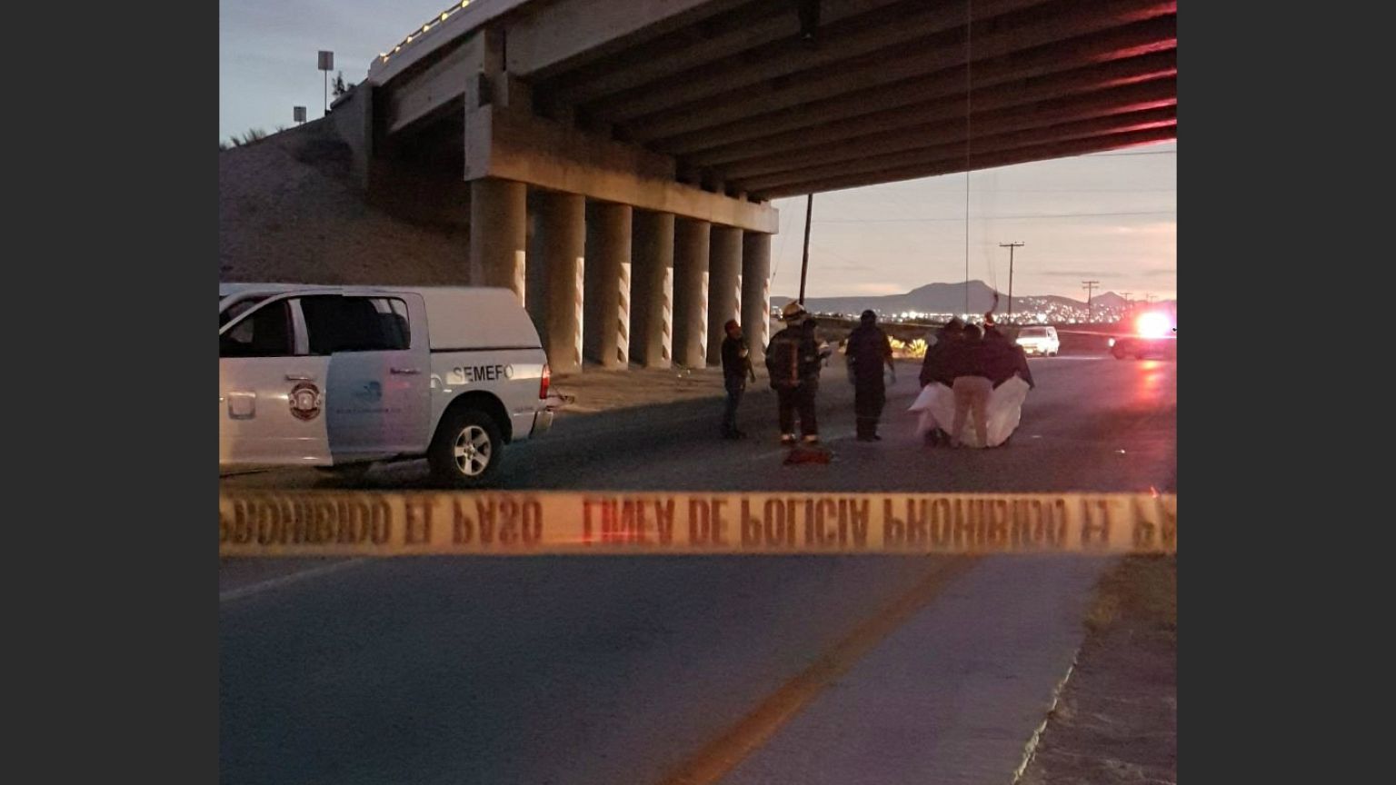 Rescuers attend to bodies that were hanged on the freeway to La Paz