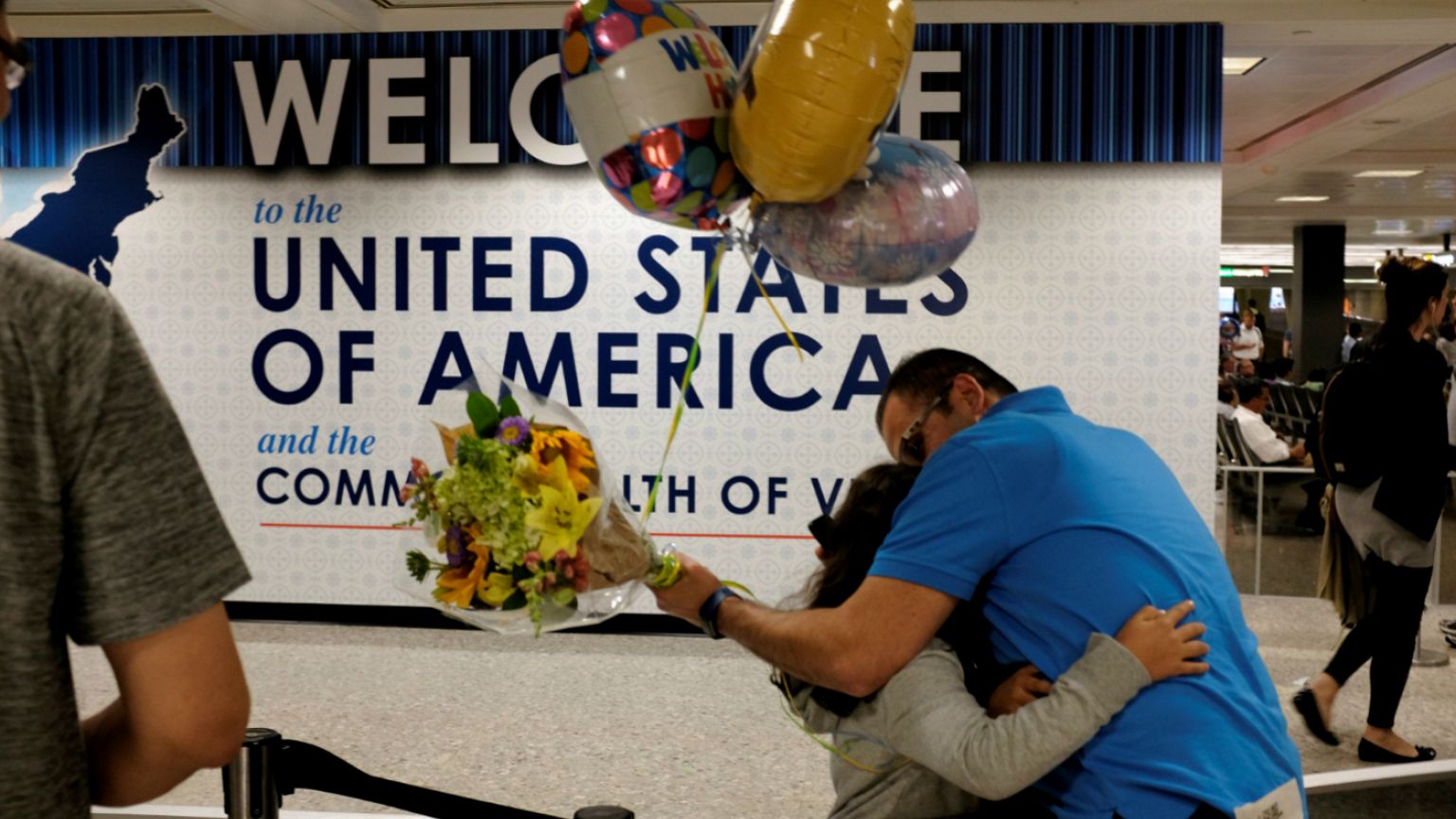 Ahmed Khalil hugs his daughters as they arrive at Washington 