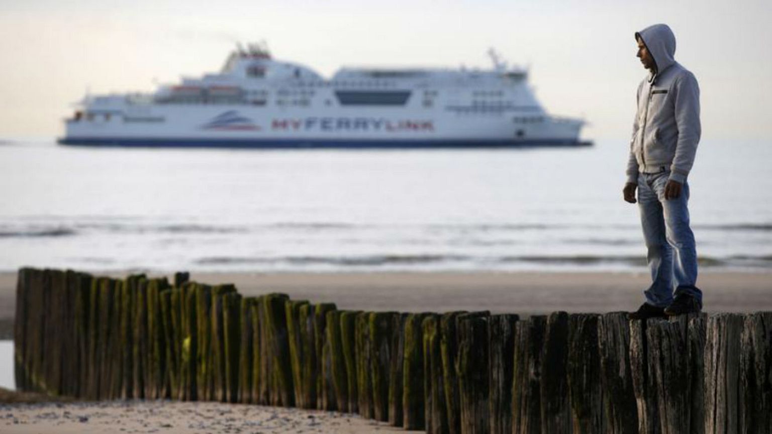 Afghan migrant Rahman Jan Safi, 24, stands on the beach front in Calais
