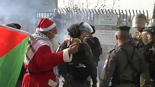Palestinos vestidos de Papá Noel se encaran a soldados israelíes