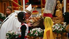 Pope Francis kisses a statuette of baby Jesus