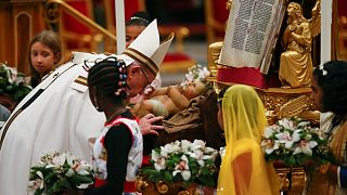 Pope Francis kisses a statuette of baby Jesus