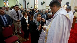 Iraqi Christian receive holy communion during a mass on Christmas