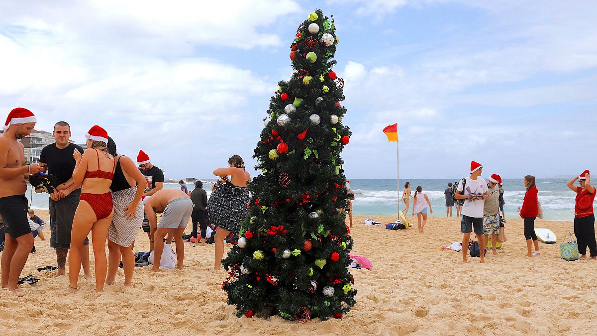 Festive revellers brave the cold and strip down to their bikinis to spend Christmas on the beach