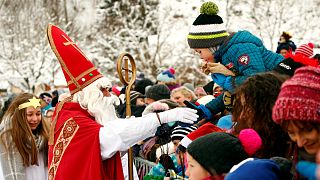 A Santa Claus waves to children