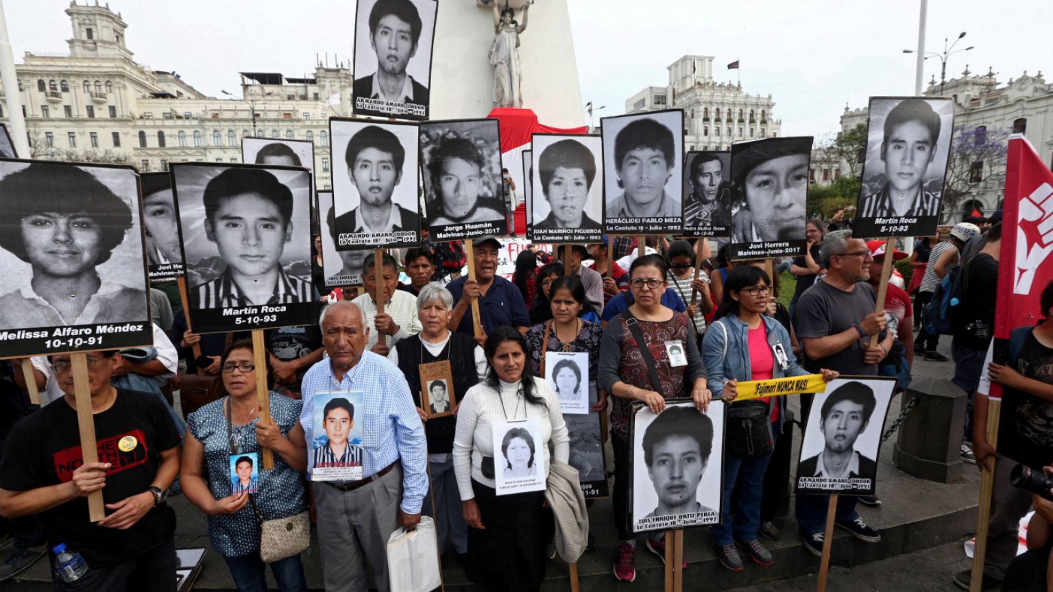 People holding pictures of victims of the guerrilla conflict