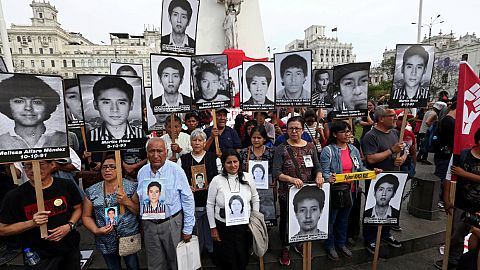 People holding pictures of victims of the guerrilla conflict